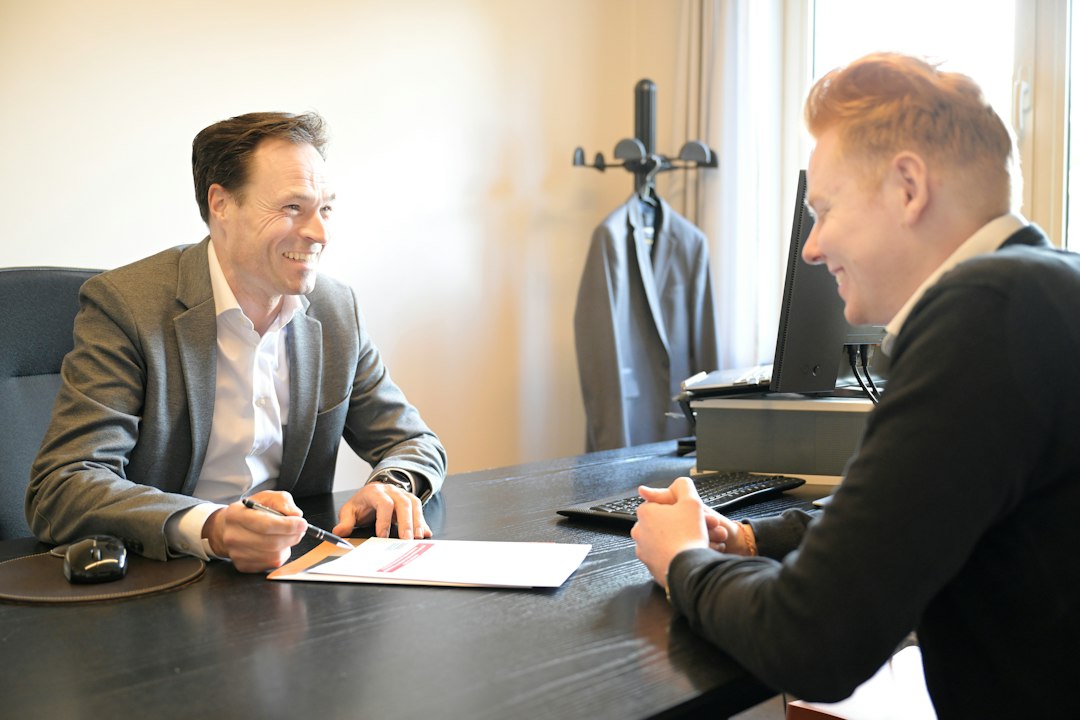 Two professionals discussing a policy document at an office desk