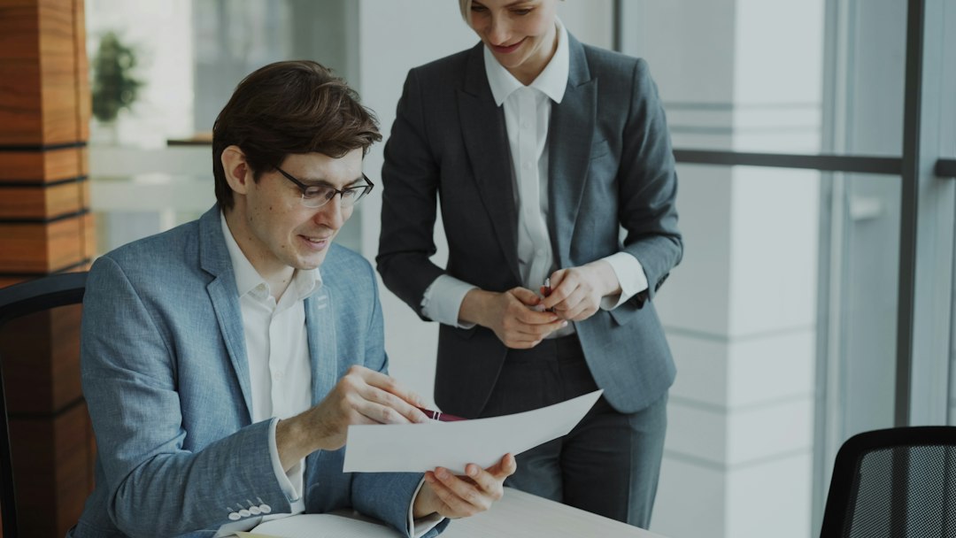 Two colleagues reviewing an AI governance document together in a modern office