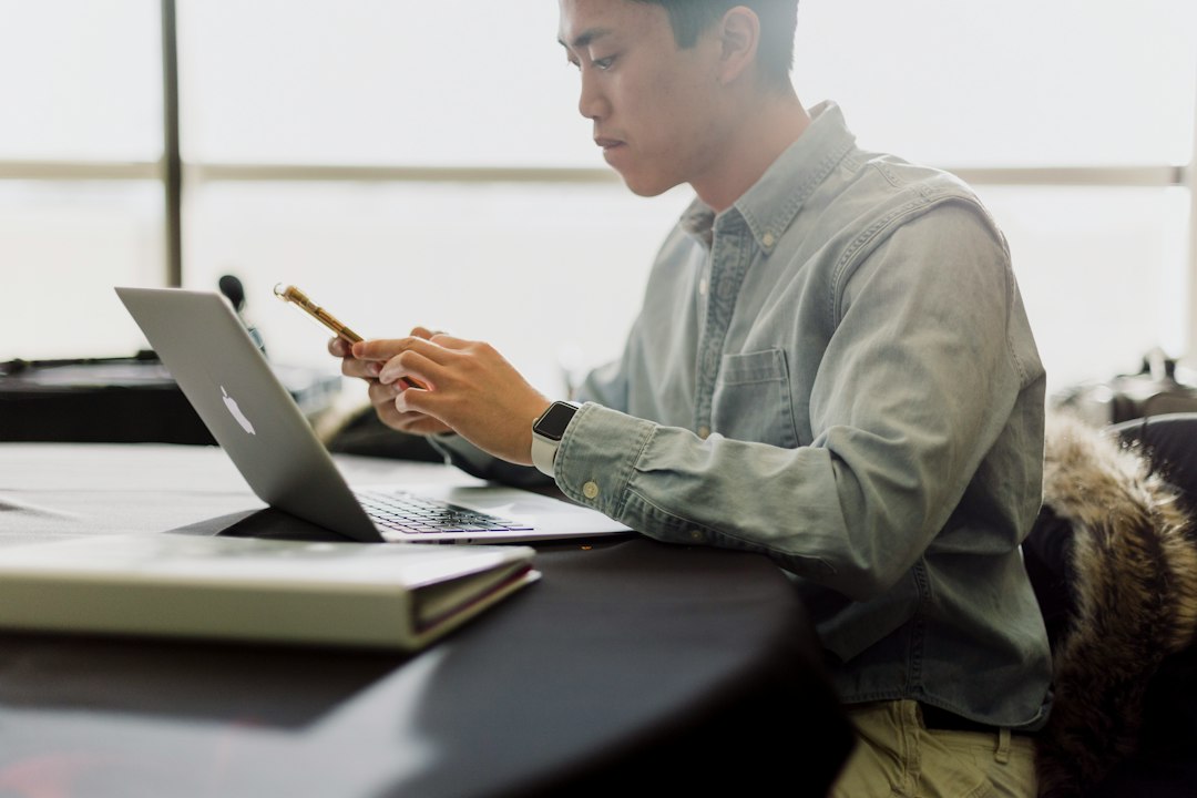 A professional reviewing documents with a pen at a desk in an office