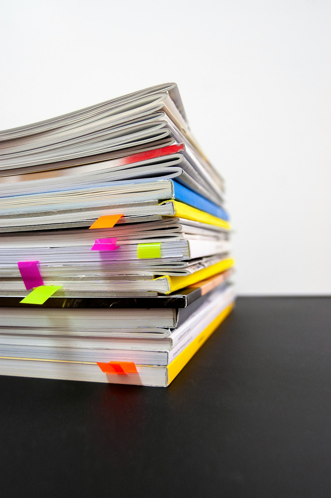 A stack of notebooks marked with colourful sticky tabs — the accumulated record you comb through to find the AI in use