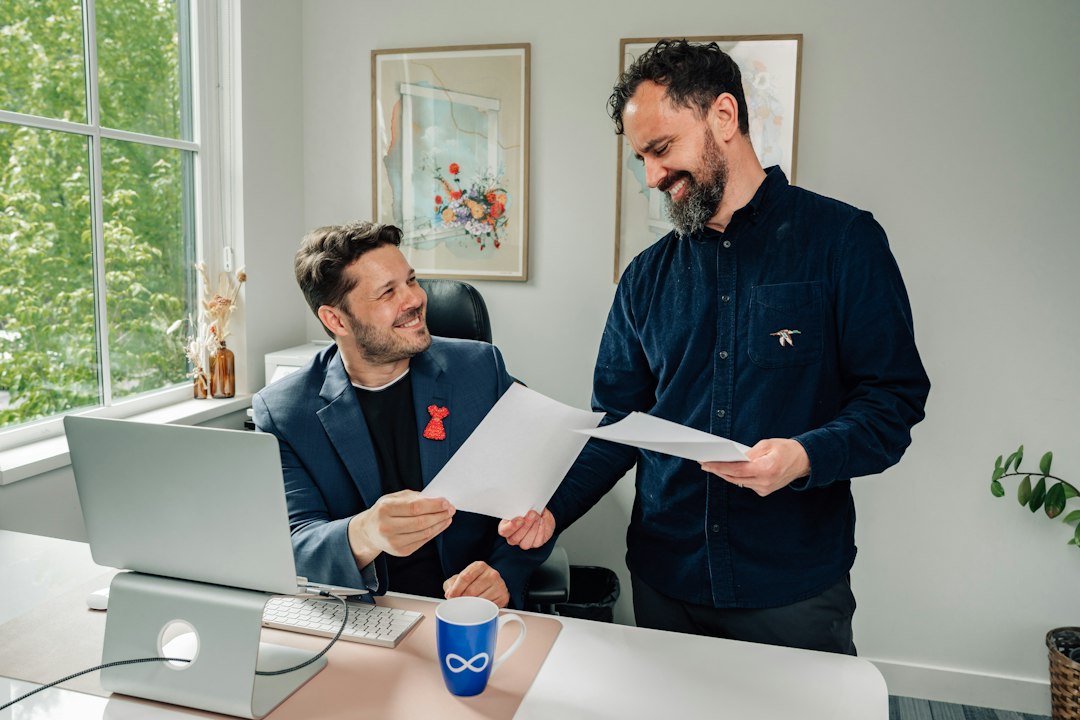 Two colleagues reviewing a document together at an office desk