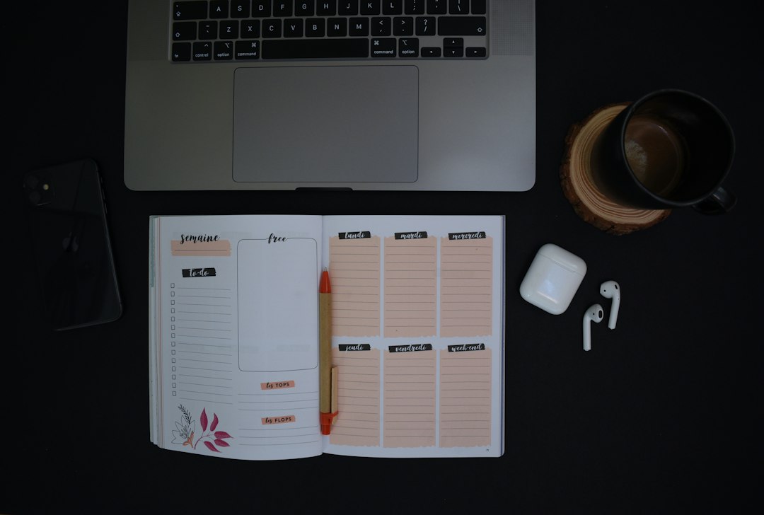 A weekly planner notebook beside a laptop and coffee, tracking steady progress between visits