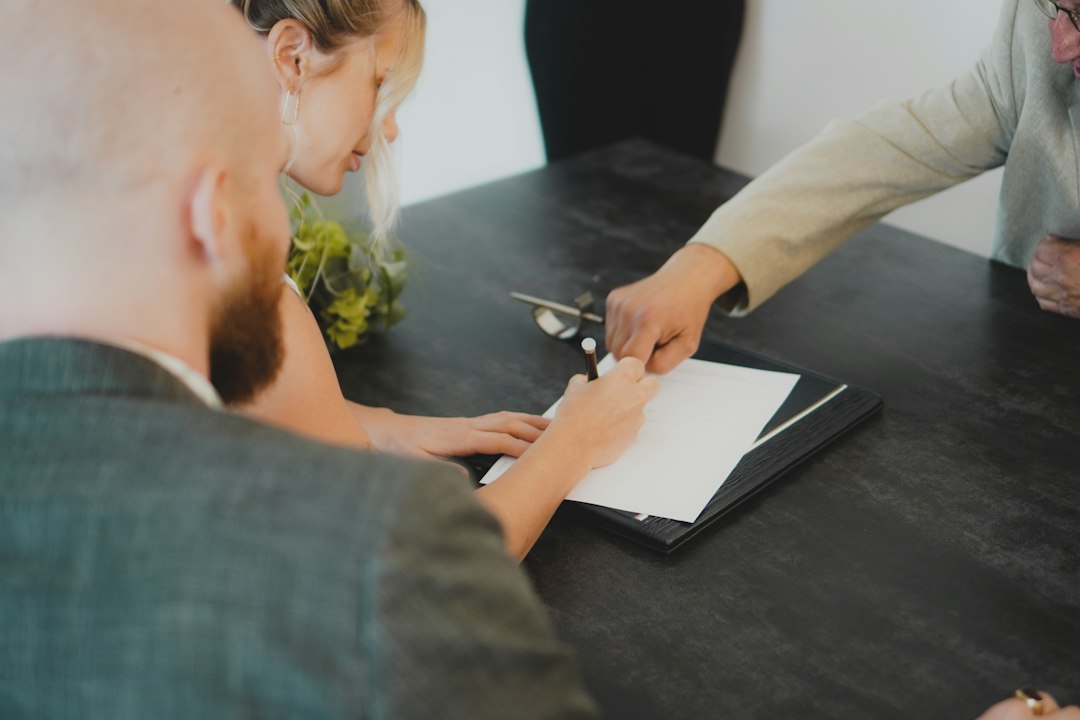 A person signing a document on a clipboard at an office counter