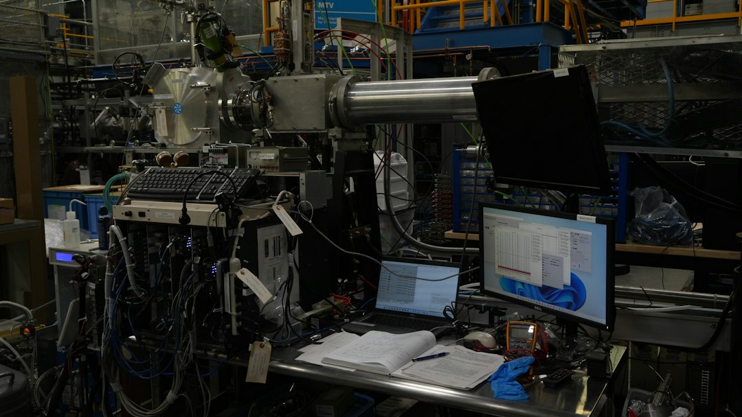 A complex scientific research facility with equipment, cabling, and computer monitors in a modern lab