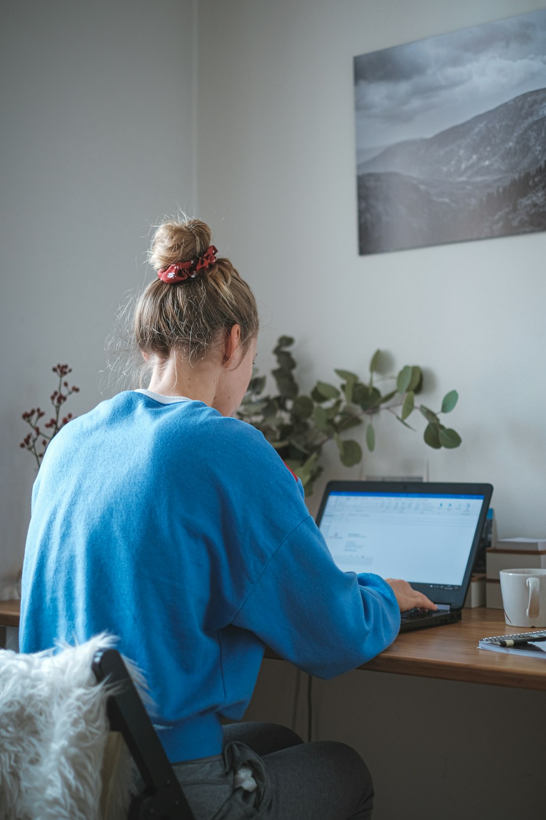 A person working on a laptop at a desk in a quiet office
